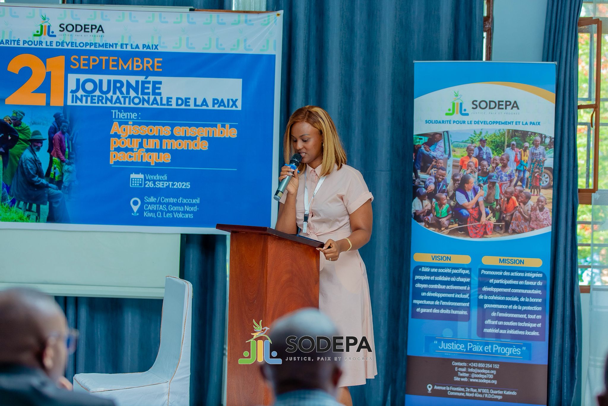 Nicole speaking on stage at a large event